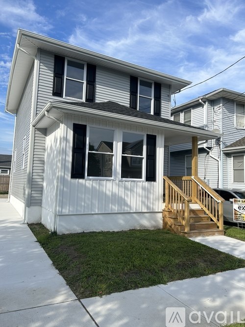 A two-story house with a wooden staircase leading to the front door.