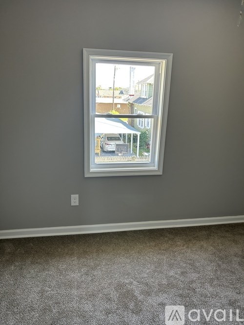 A window in a room with a car parked outside.