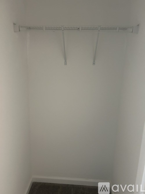 A white wall with a clothes rack mounted on it.