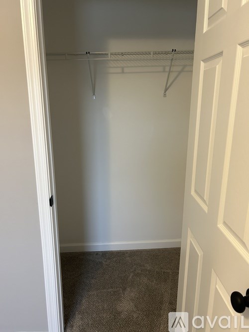 A white door with a black handle and a white wall.