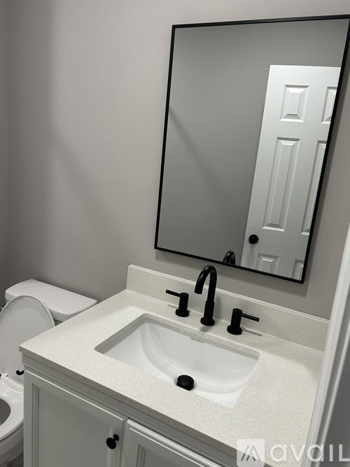 A bathroom with a sink, mirror, and toilet.