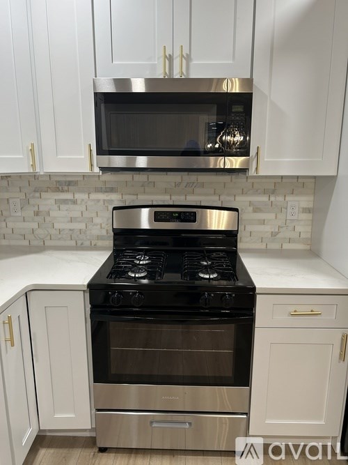 A kitchen with a stove and microwave above it.