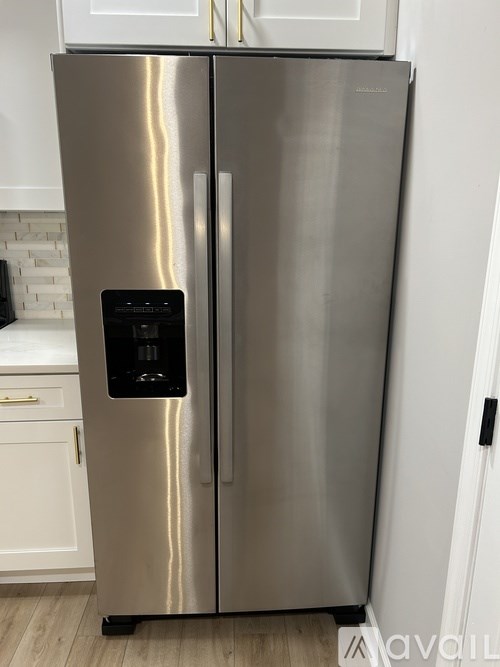 A stainless steel refrigerator with a water and ice dispenser in the door.