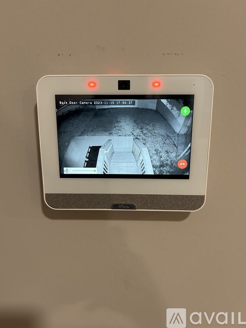A security camera displays a live feed of a room with a green light indicating no intruders.