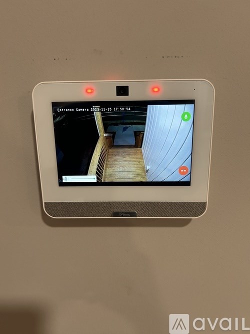 A security camera is mounted on a wall and is turned on.