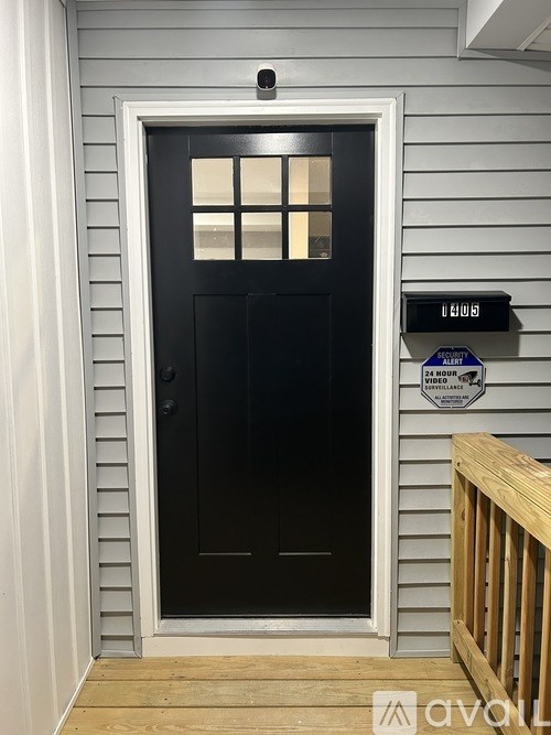 A black door with a window in the middle and a digital clock above it.