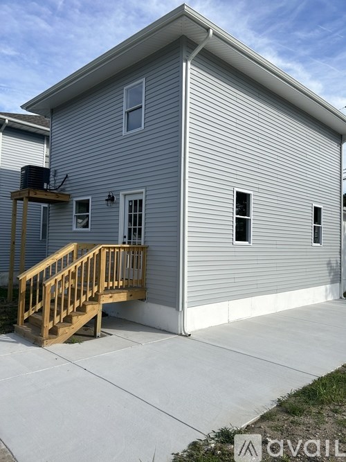 A house with a grey siding and a wooden deck.