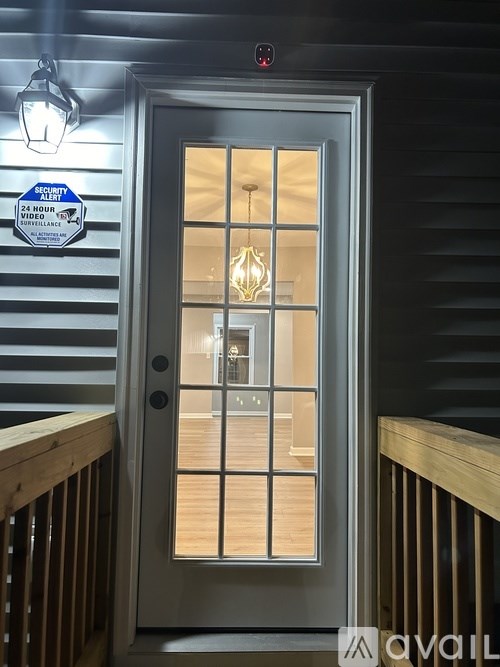 A glass door with a wooden frame and a sign on the wall.