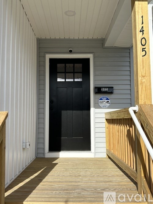 A black door is on the right side of a white wall.