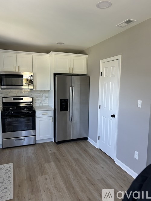 A kitchen with a refrigerator, stove, and microwave.