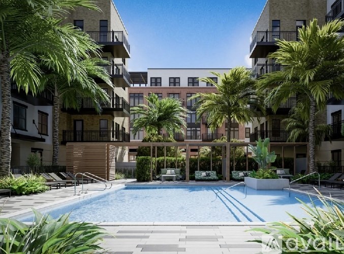 A swimming pool surrounded by palm trees and apartment buildings.