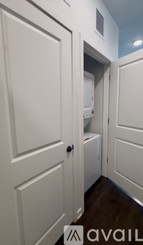 A white door with a black handle is in a room with white walls.