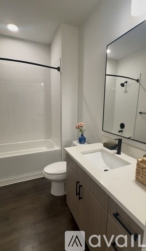 A bathroom with a toilet, sink, and mirror.