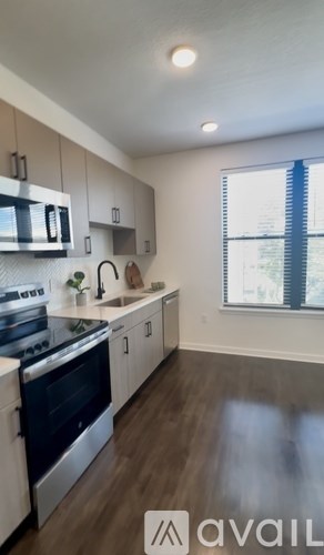 A kitchen with a stove top oven and a window.