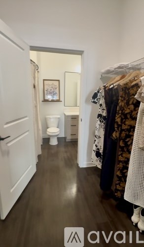 A hallway with a toilet and a mirror.