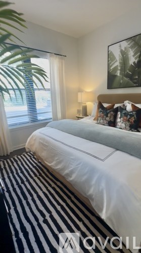 A bedroom with a large bed and a painting on the wall.