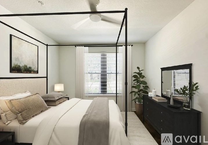 A bedroom with a four poster bed and a ceiling fan.