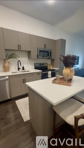 A conference room with a long table and chairs, a laptop on the table, and a plant on the side.
