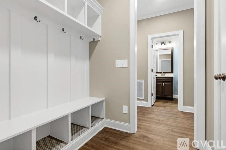 A hallway with a bench and coat hooks.