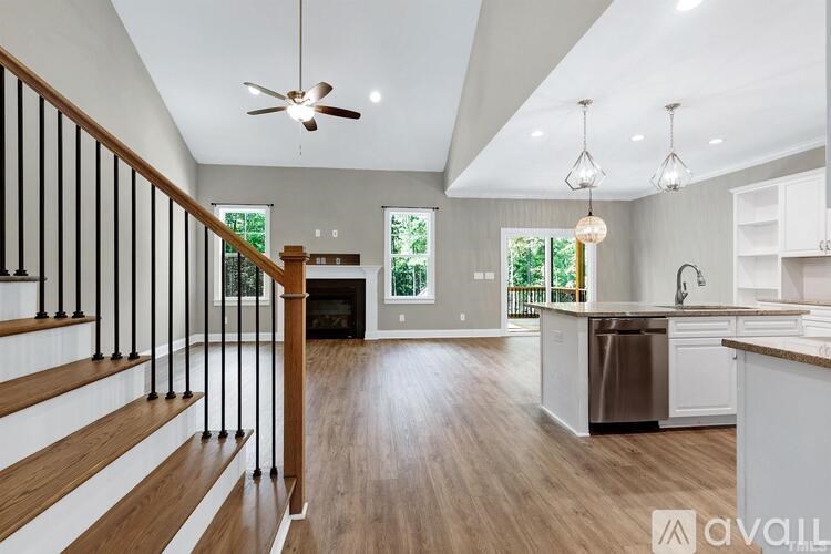 A modern kitchen with a wooden floor and white cabinets.