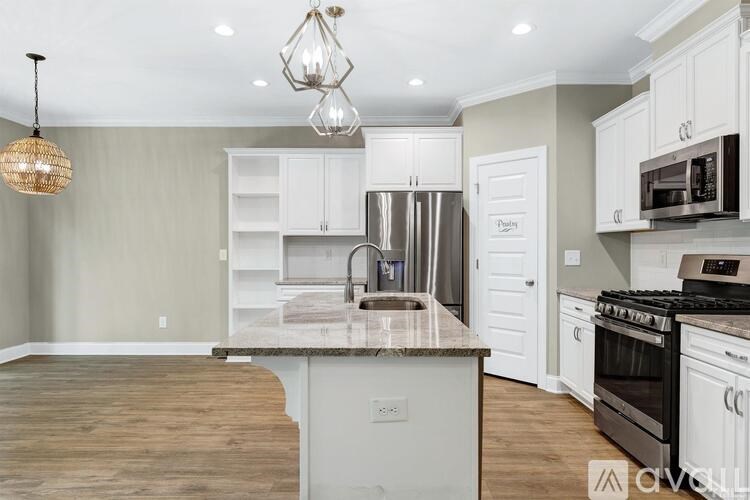A kitchen with a granite countertop and stainless steel appliances.