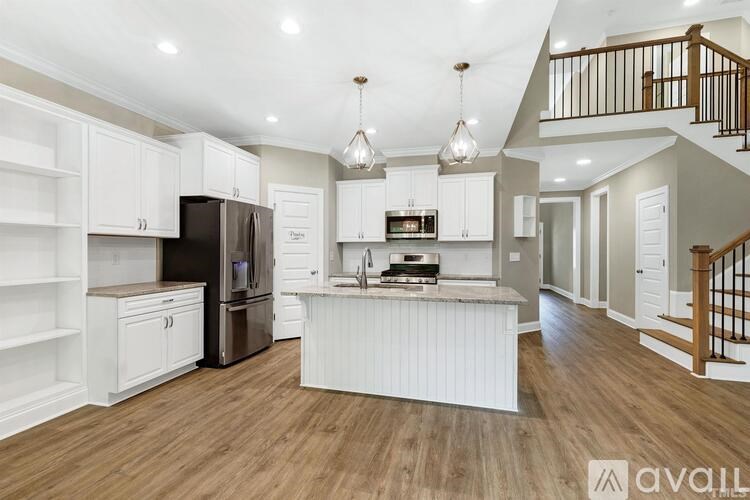 A kitchen with white cabinets and a wooden floor.