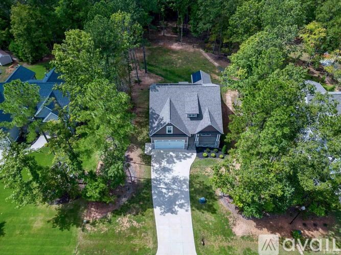 A house with a grey roof is surrounded by trees.