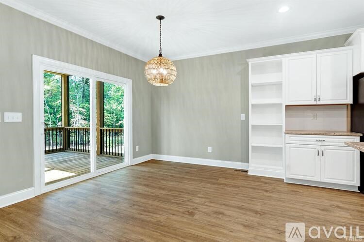 A room with a wooden floor and a hanging light fixture.