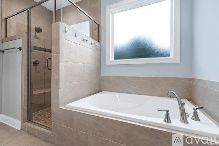A modern bathroom with a large tub and a glass shower stall.