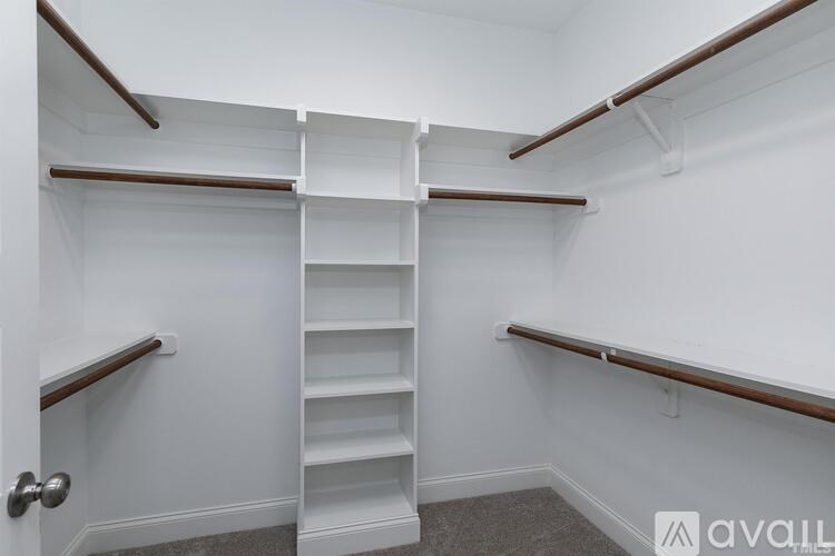 A white closet with a staircase and shelves.