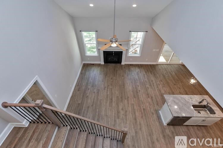 A wood floor leads up to a skylight in a white room.