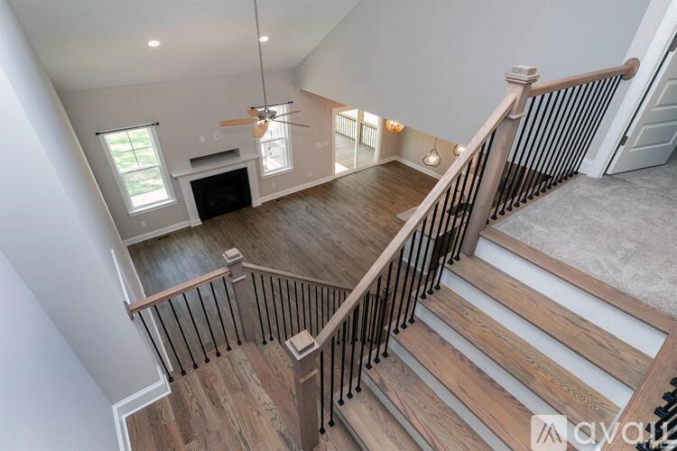 A living room with a fireplace and a staircase.
