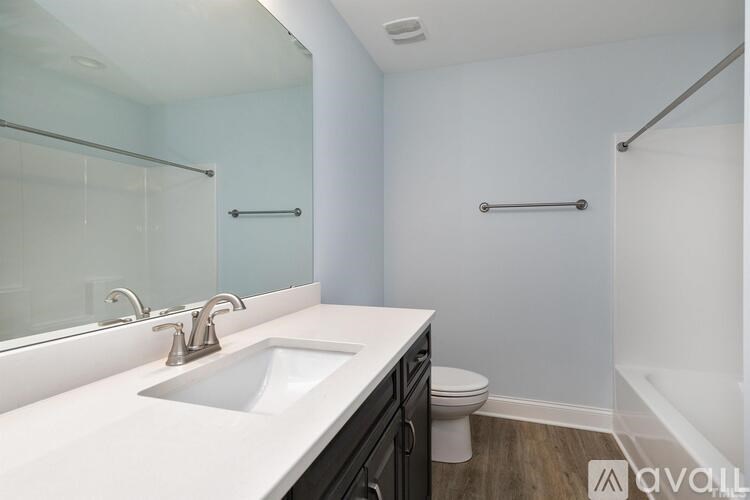 A bathroom with a sink, mirror, toilet and shower.