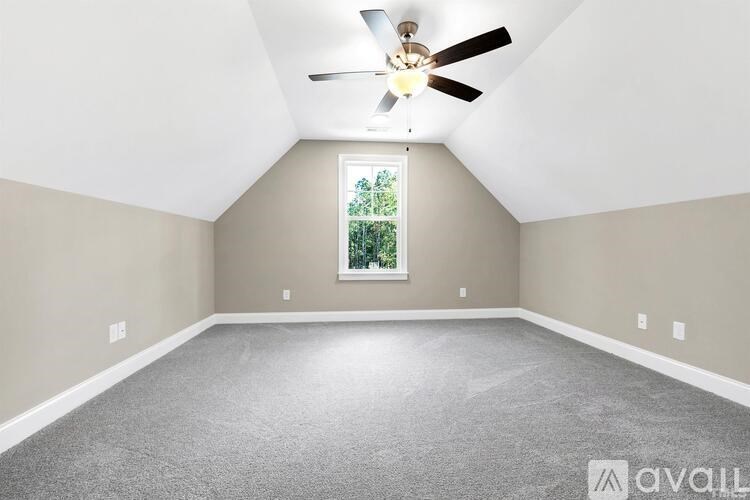 A room with a ceiling fan and a window.