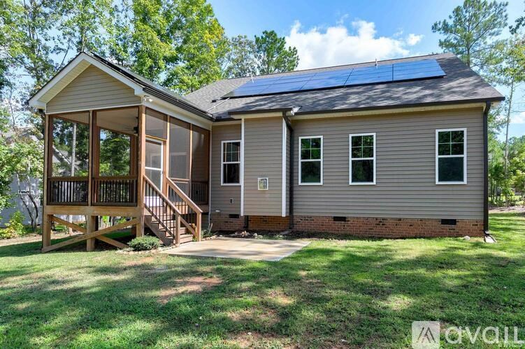 A house with a deck and solar panels on the roof.