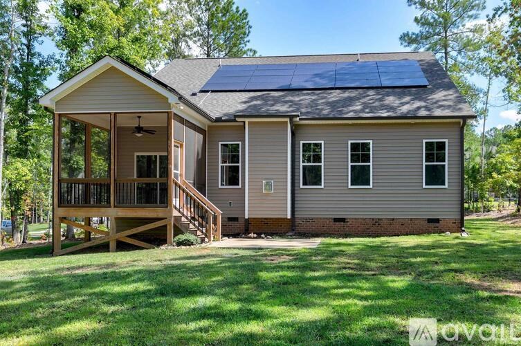 A house with a porch and solar panels on the roof.