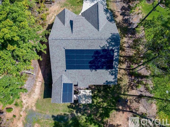 A modern house with a triangular roof and a large glass window.