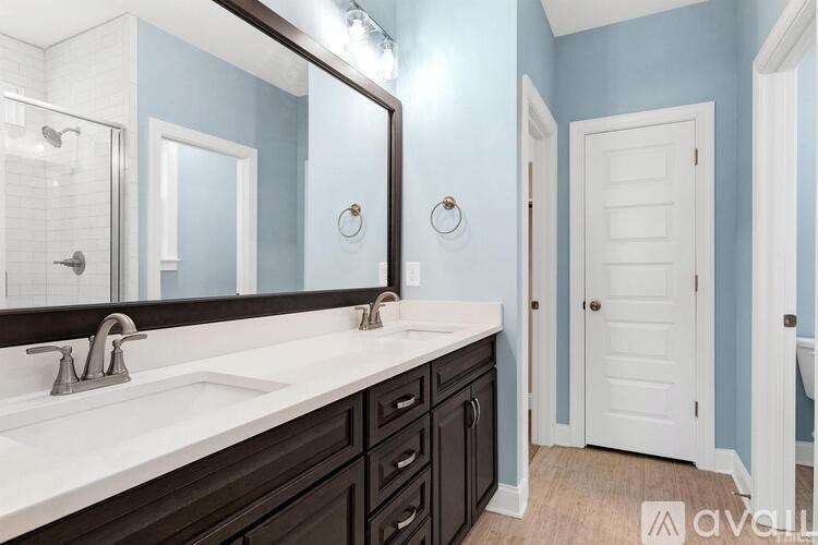A bathroom with a white sink and a mirror above it.