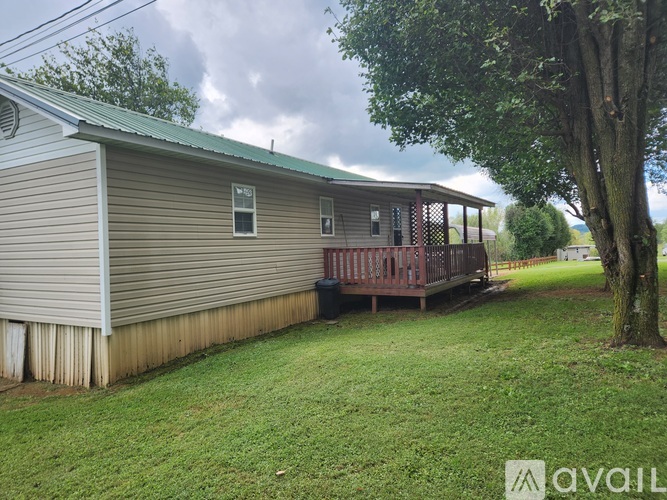 A house with a porch and a tree in front.