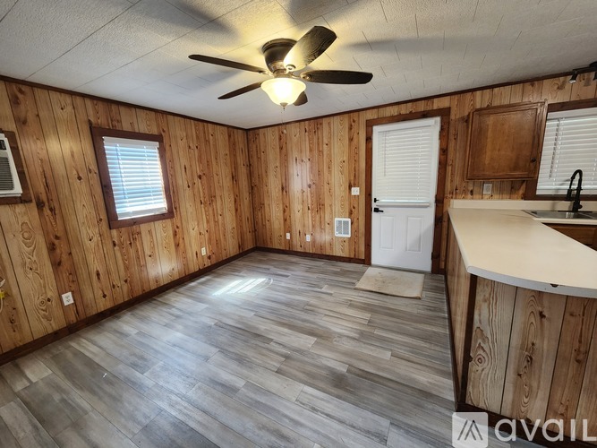 A room with wooden walls and a ceiling fan.