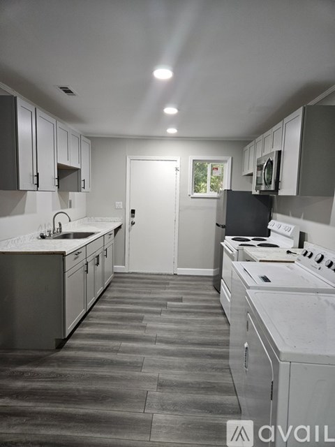 A kitchen with a white counter top and a white sink.