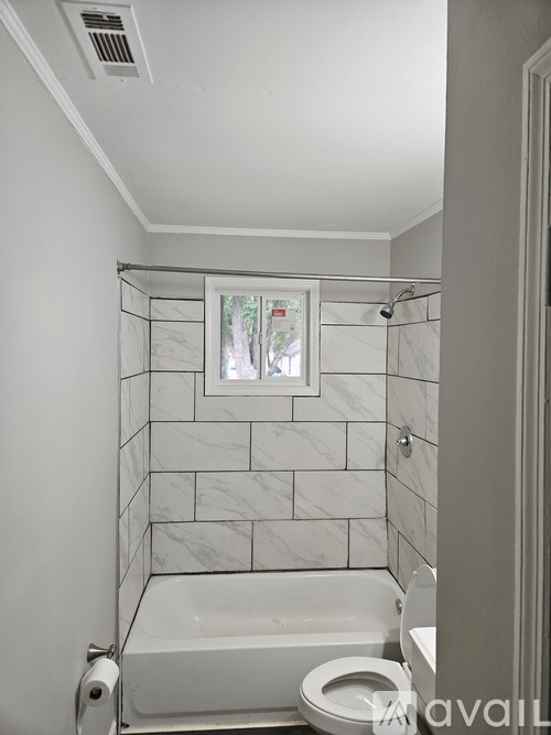 A white bathroom with a marble tile shower.
