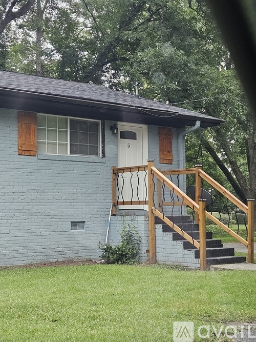 A house with a blue exterior and a wooden staircase leading to the front door.