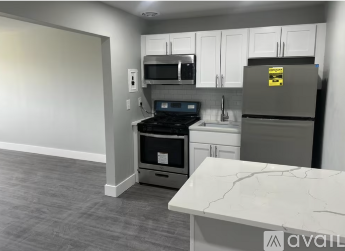 A kitchen with a refrigerator, oven, and microwave.