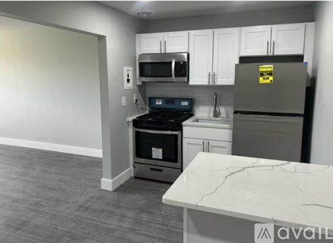 A kitchen with a refrigerator, oven, and microwave.