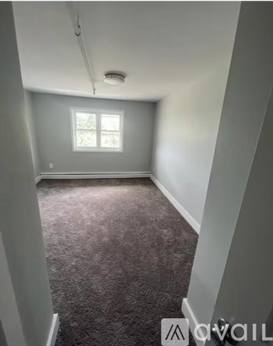 A room with a carpeted floor and a window.