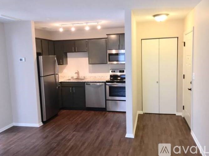 A kitchen with dark wood floors and modern appliances.
