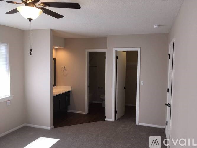 A room with a ceiling fan and a bed in it.