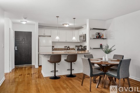 A kitchen with a dining table and chairs.