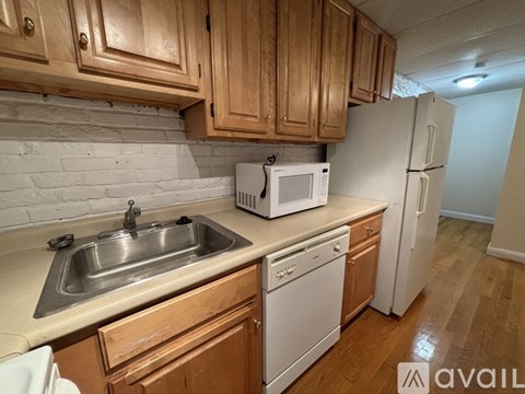 A kitchen with wooden cabinets and a white refrigerator.